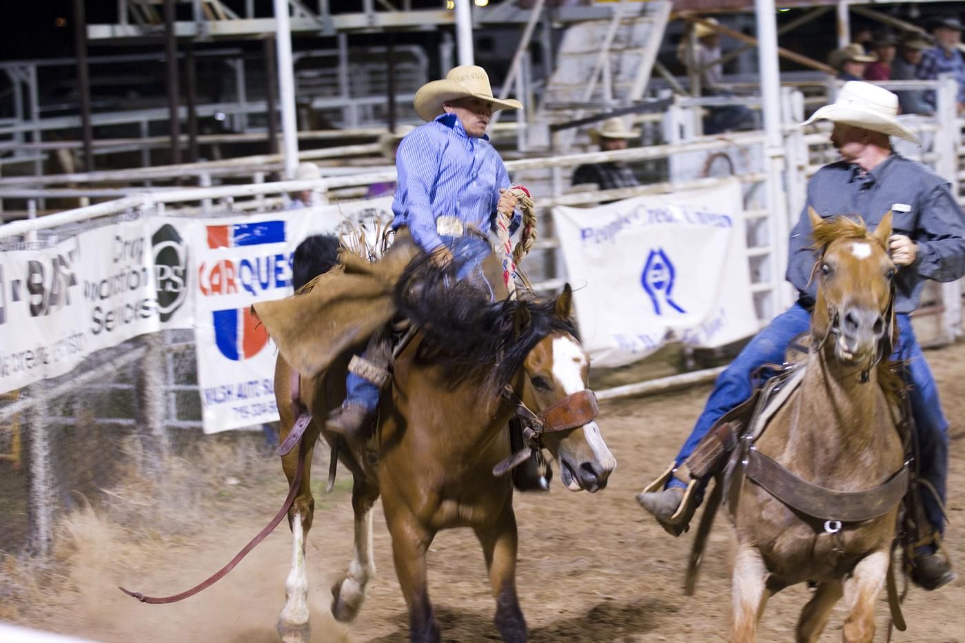 pro rodeo cowboy on horse near other cowboy