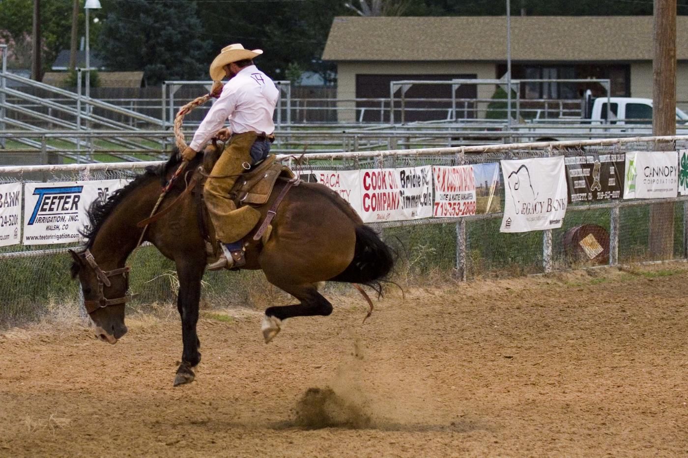 pro rodeo cowboy on horse jumping back feet up